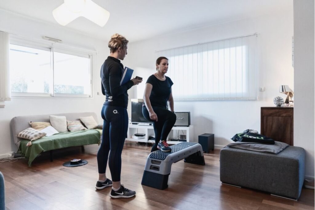 Une cliente et sa coach sportif font une séance de la salon de la cliente.