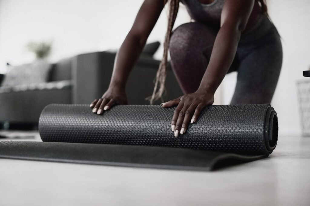 Une cliente met en place un tapis de yoga pour faire des exercices.