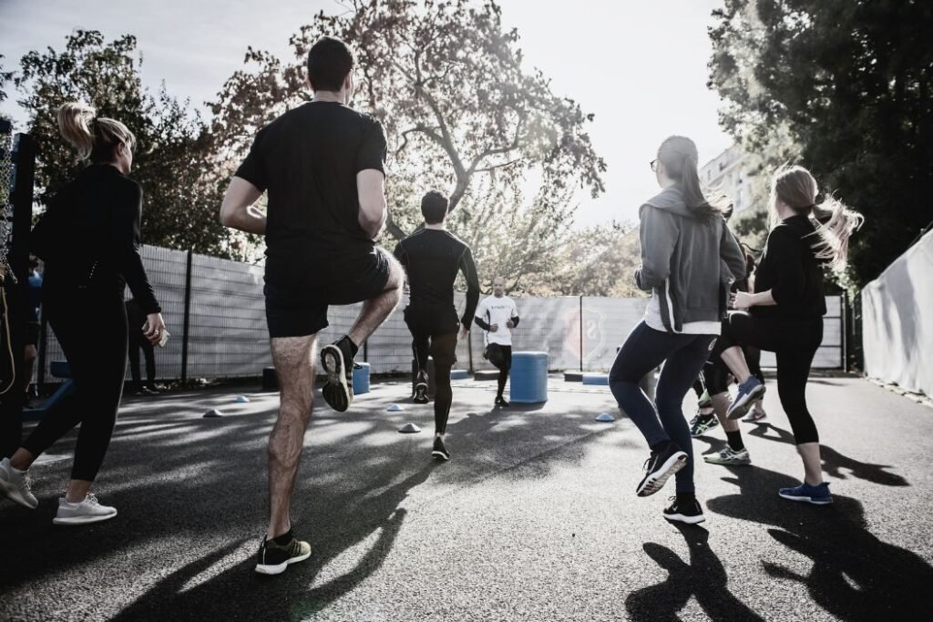 Des employés font du sport en extérieur avec un coach.