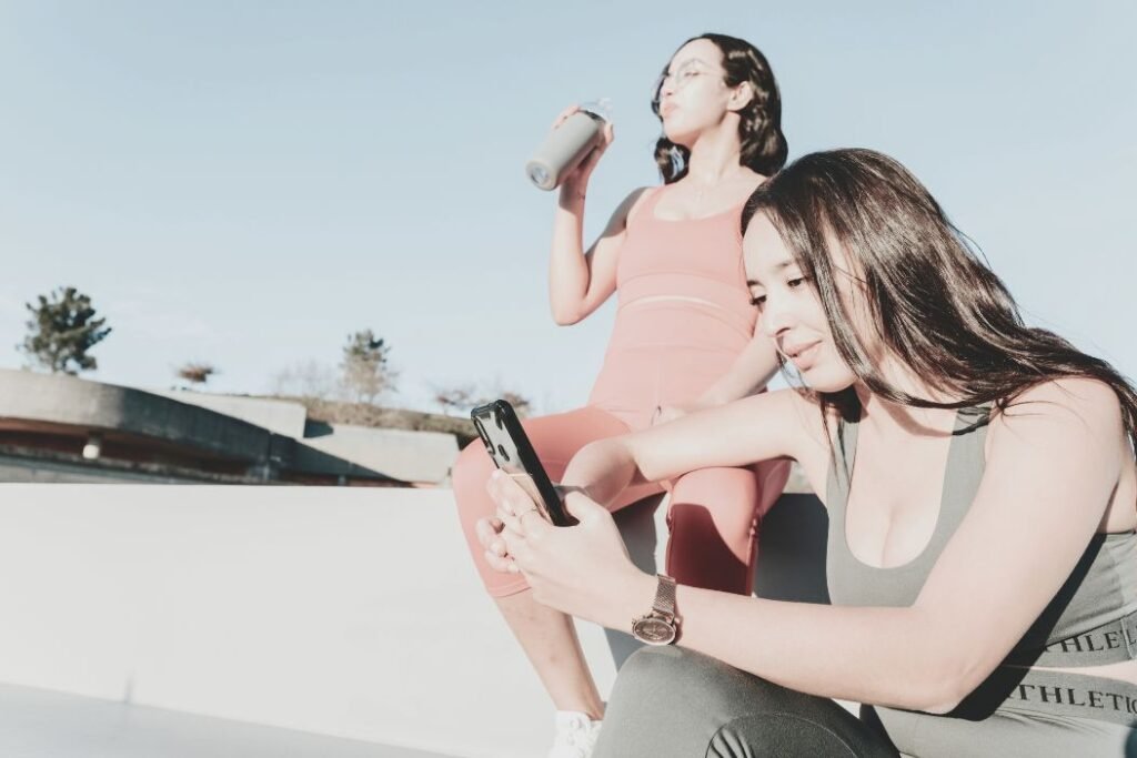 Deux femmes se connectent avec leur coach sportif grâce à leur téléphone.