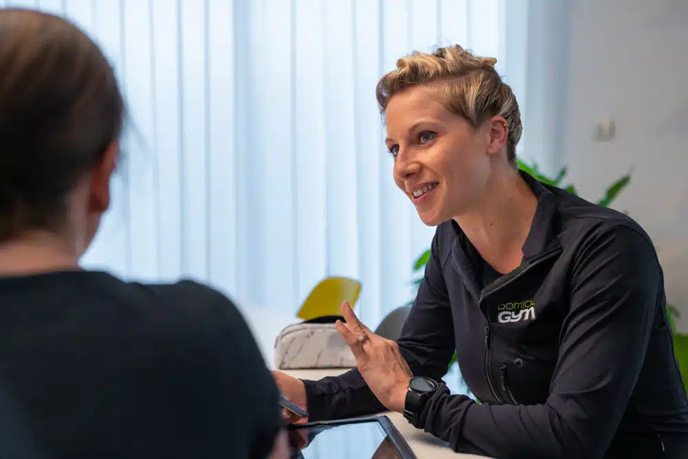 Une coach est assise à table avec sa cliente pour discuter de ses objectifs.