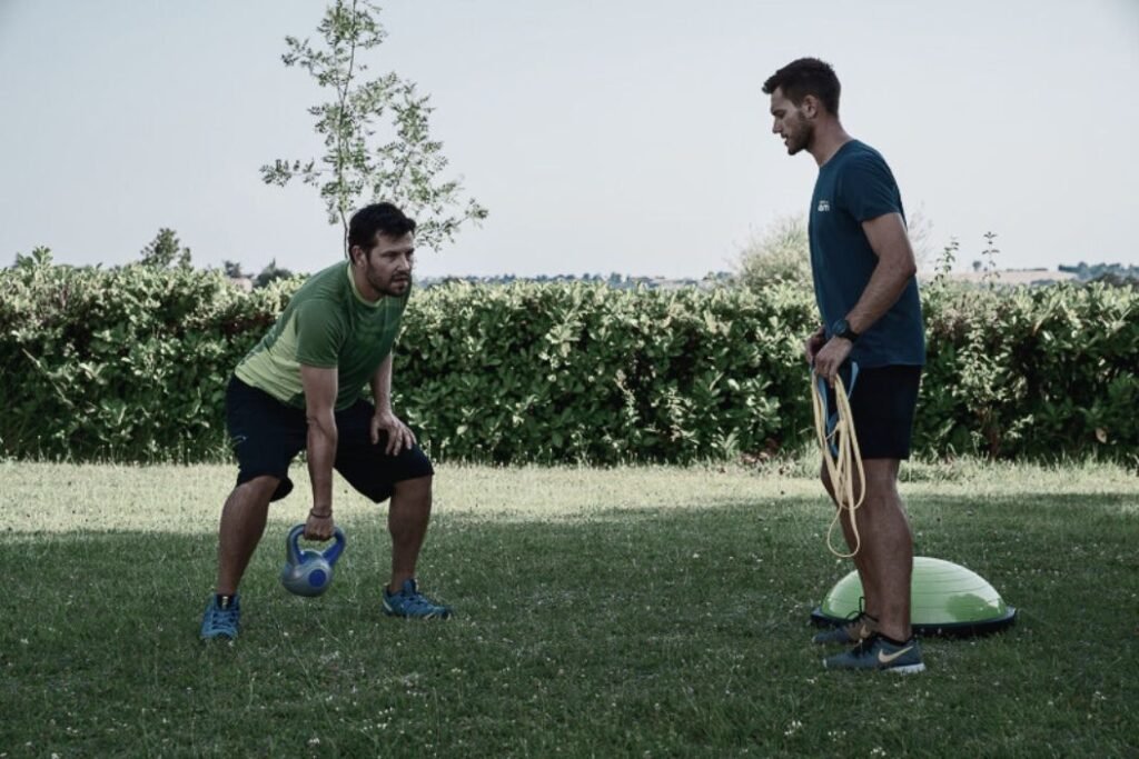 Un coach sportif et son client réalise un exercice dans le jardin.