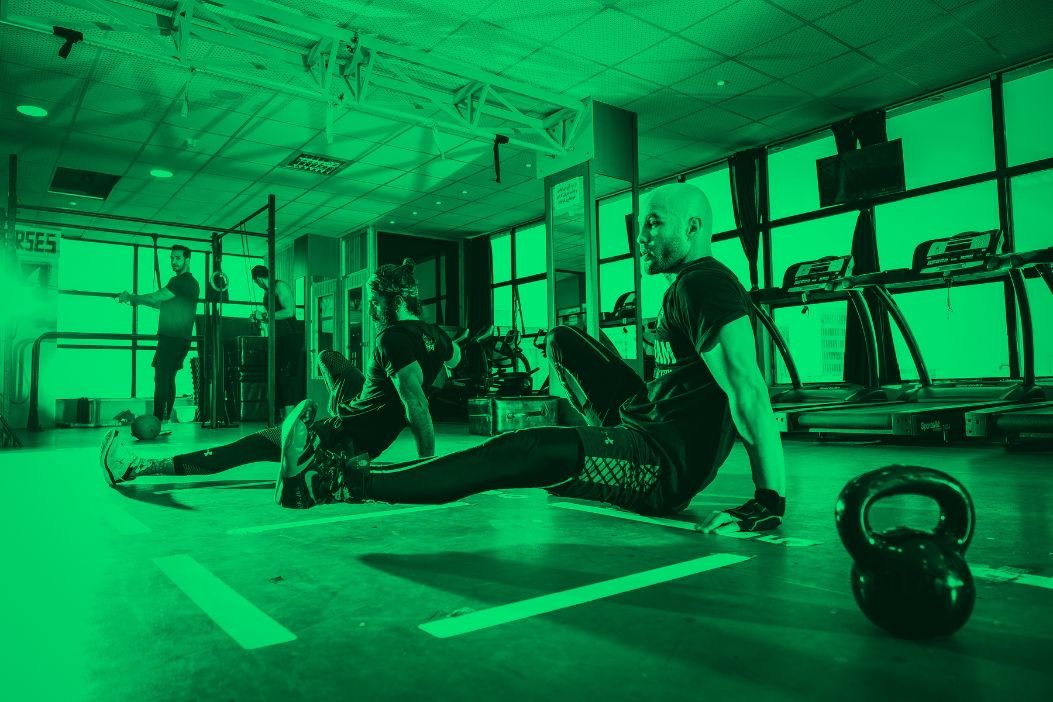 Plusieurs personnes en salle de sport se forment au métier de coach sportif.