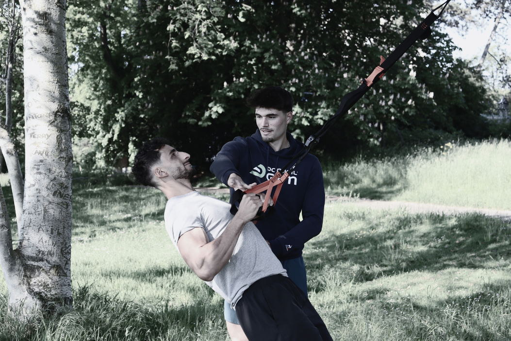 Une coach sportif regarde sa cliente faire un exercice.