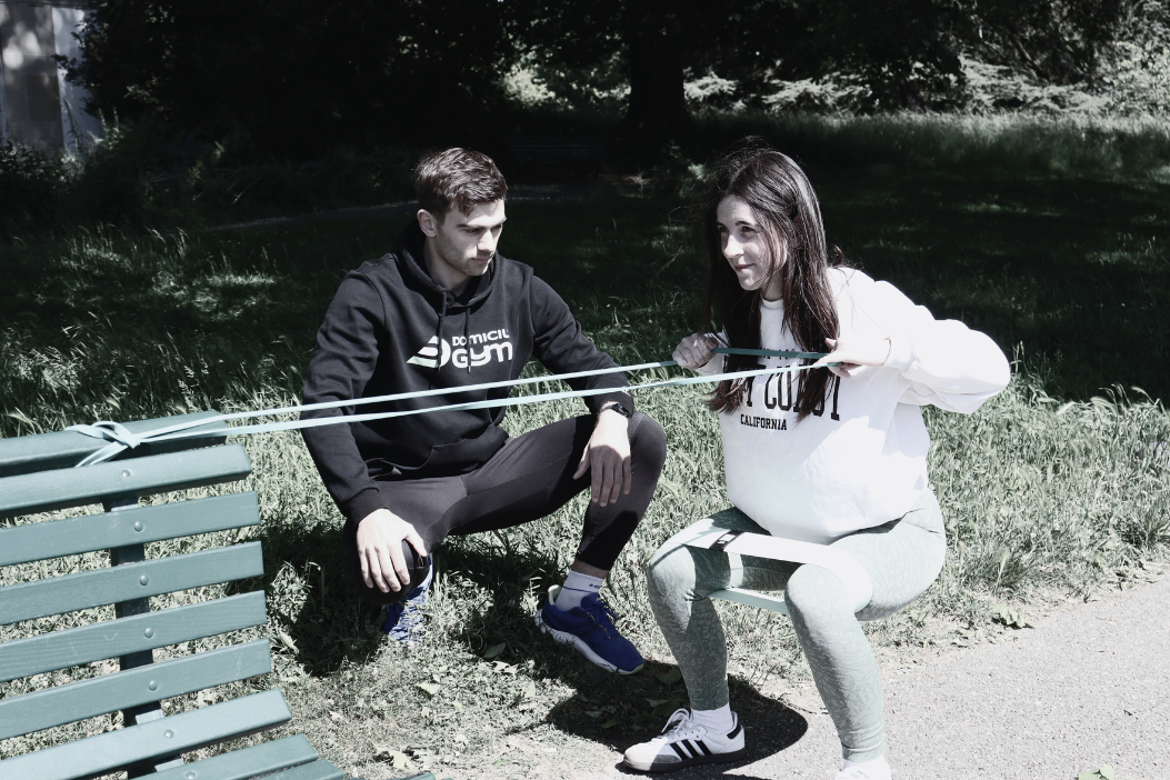 Une coach sportif regarde sa cliente faire un exercice.